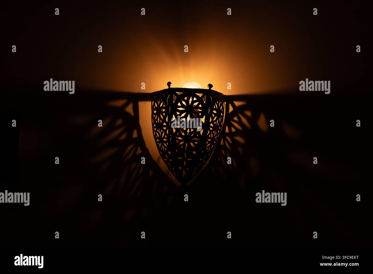 Lampa che crea un'ombra a motivi sul muro Foto Stock