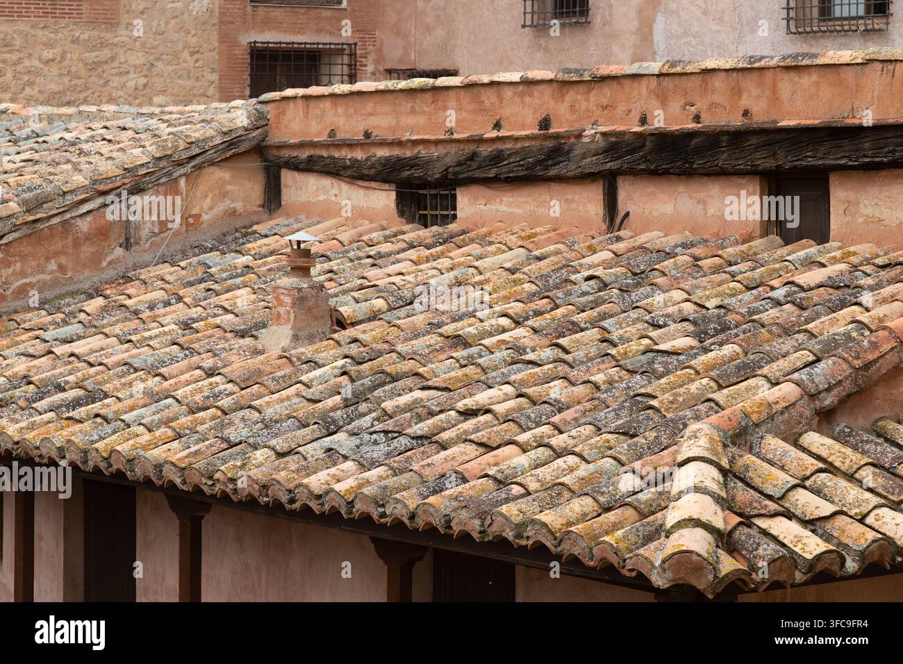 Vecchie tegole sul tetto di edifici in arenaria rosa nell'antica città storica di Albarracin, Spagna, Europa Foto Stock