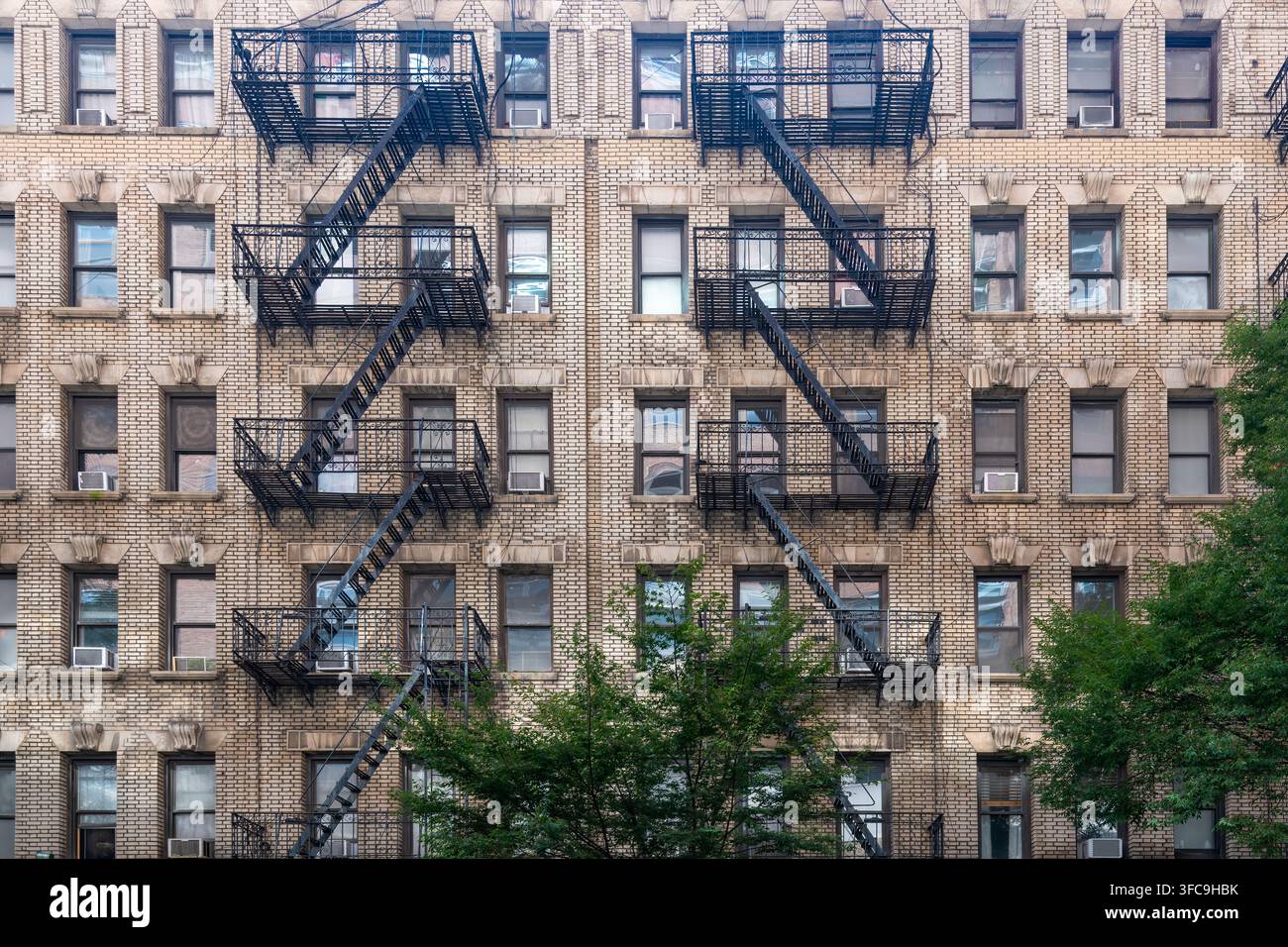 Una vista ravvicinata della facciata simmetrica in mattoni di un edificio residenziale tradizionale di New York Foto Stock