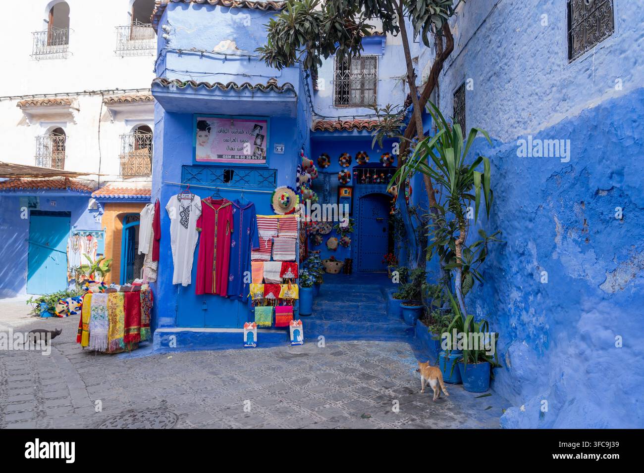 Case e strade di colore blu con souvenir turistici esposti in vendita a Chefchaouen, Marocco. Foto Stock