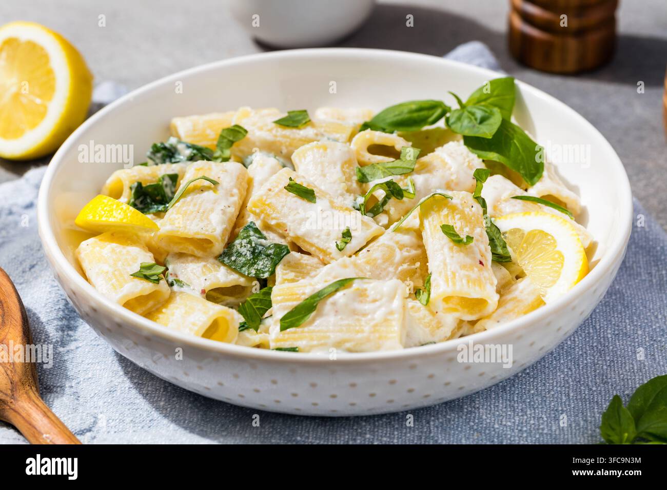Pasta rigatoni fatta in casa con ricotta al limone saporita, basilico e spinaci Foto Stock