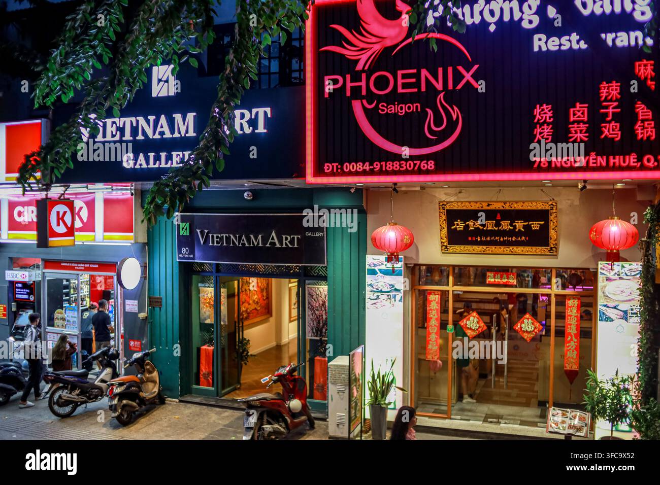 Ho Chi Minh, Vietnam - 29 luglio 2024: Una scena notturna vivace che mostra le vetrine illuminate della Vietnam Art Gallery e del ristorante Phoenix Saigon, w Foto Stock