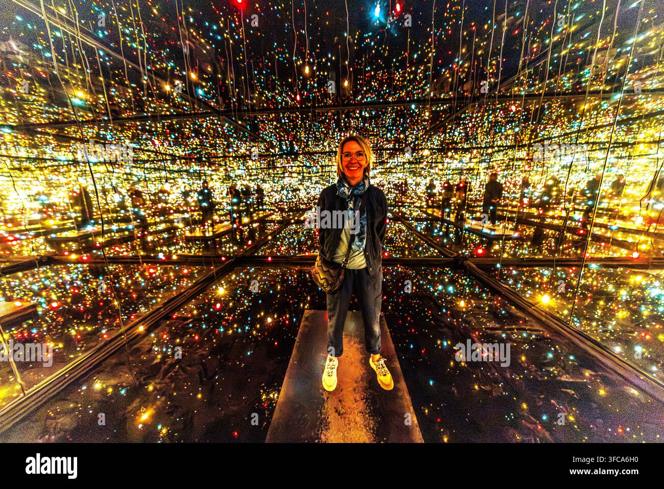 Angela Berg si trova nell'installazione luminosa ‘Infinity Mirror Room – Fireflies on the Water‘ dell'artista giapponese Yayoi Kusama al Musée des Beaux-Arts de Nancy. Innumerevoli punti di luce colorati si riflettono all'infinito nelle pareti a specchio della stanza buia. Il museo ha ricevuto l'opera in prestito dal Centre national des arts plastiques nel 2001. Foto Stock