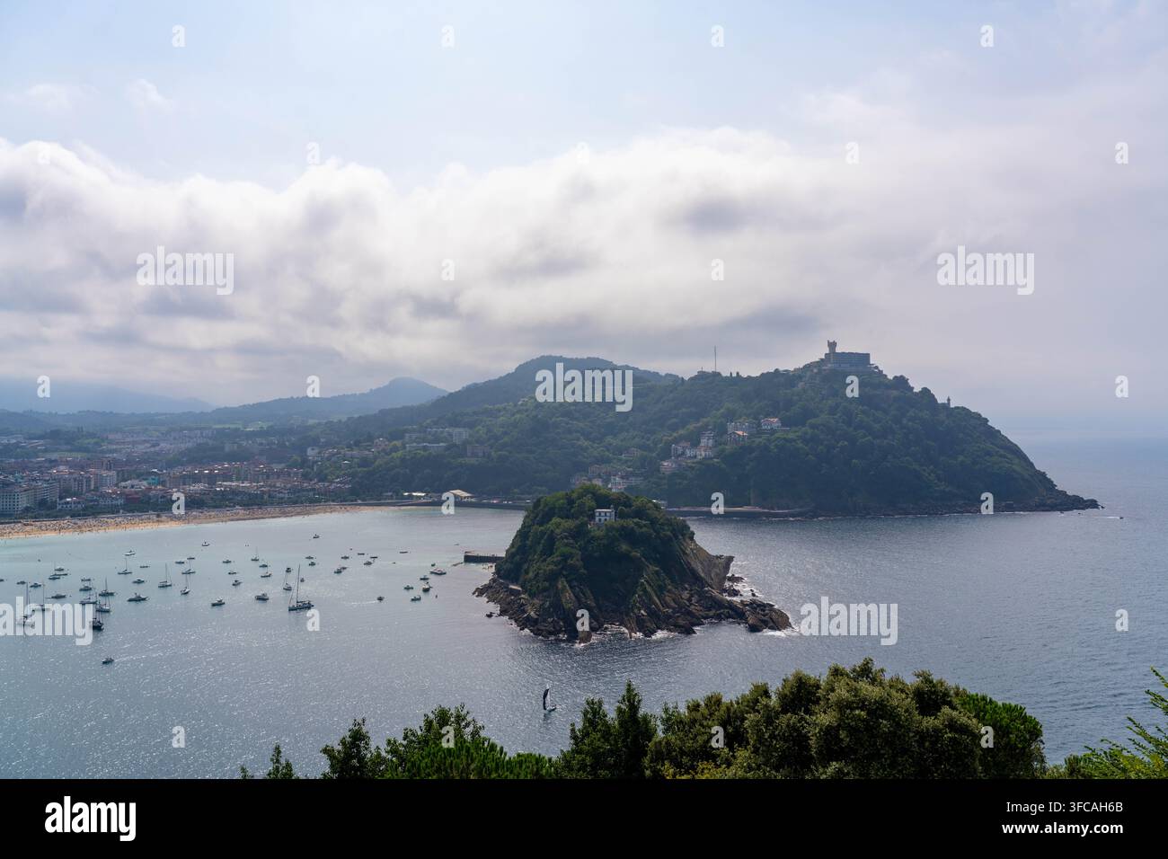 Isola di Santa Klara e barche a vela ancorate nella baia di San Sebastián in Spagna Foto Stock