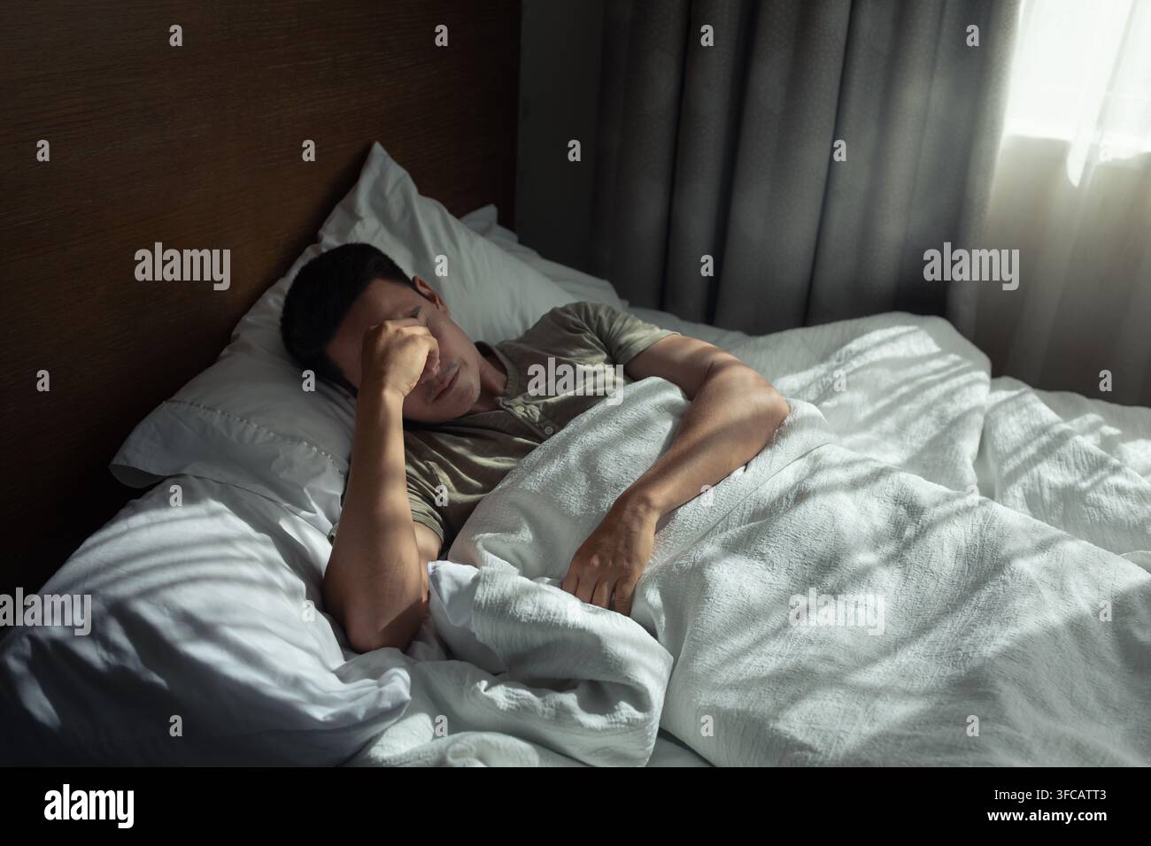 Uomo che si sveglia dopo una notte agitata. Foto Stock