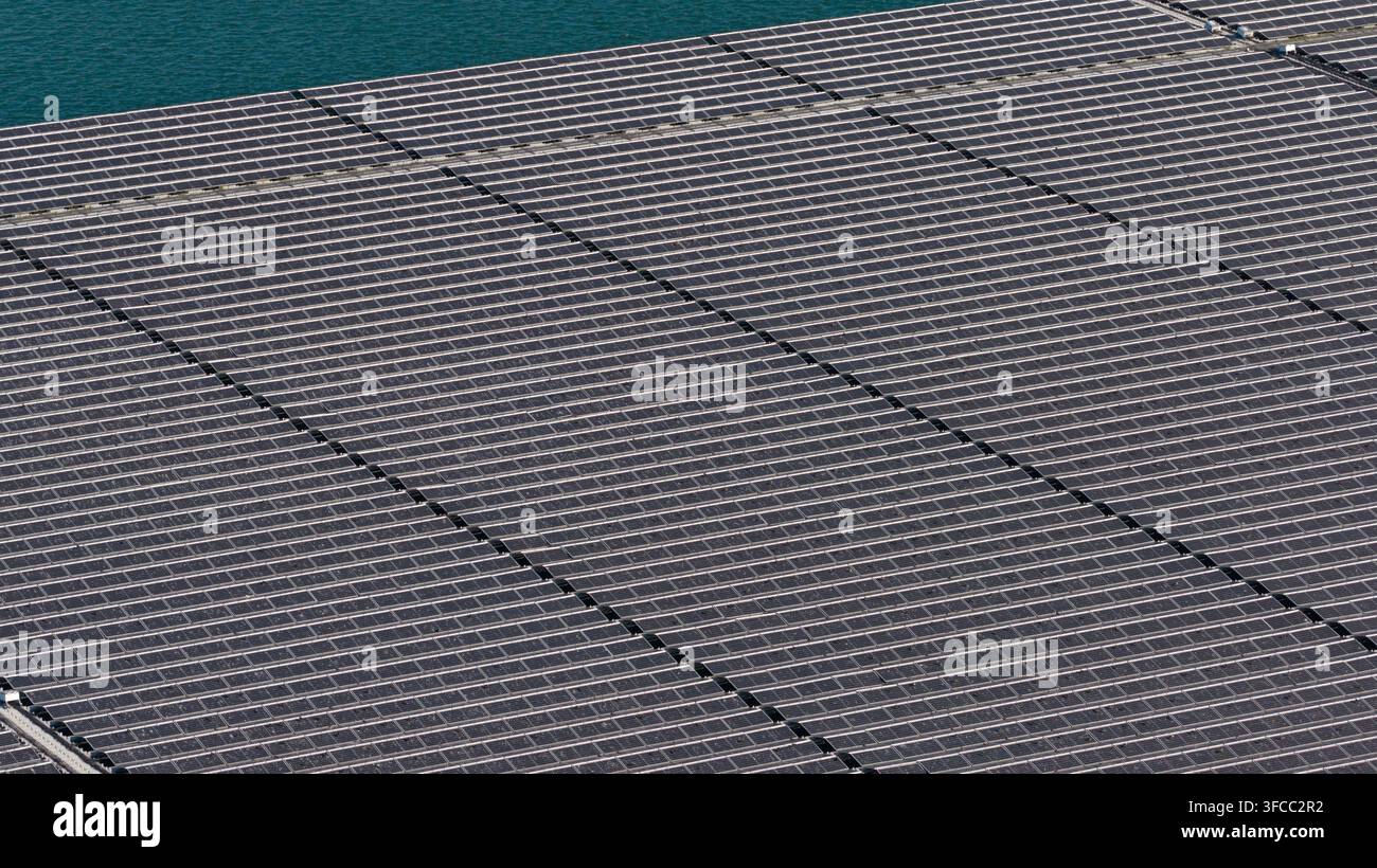 Vista aerea di una grande fattoria solare galleggiante installata su un corpo d'acqua calmo, che mostra file di pannelli fotovoltaici a Echteld, Gelderland, Paesi Bassi Foto Stock