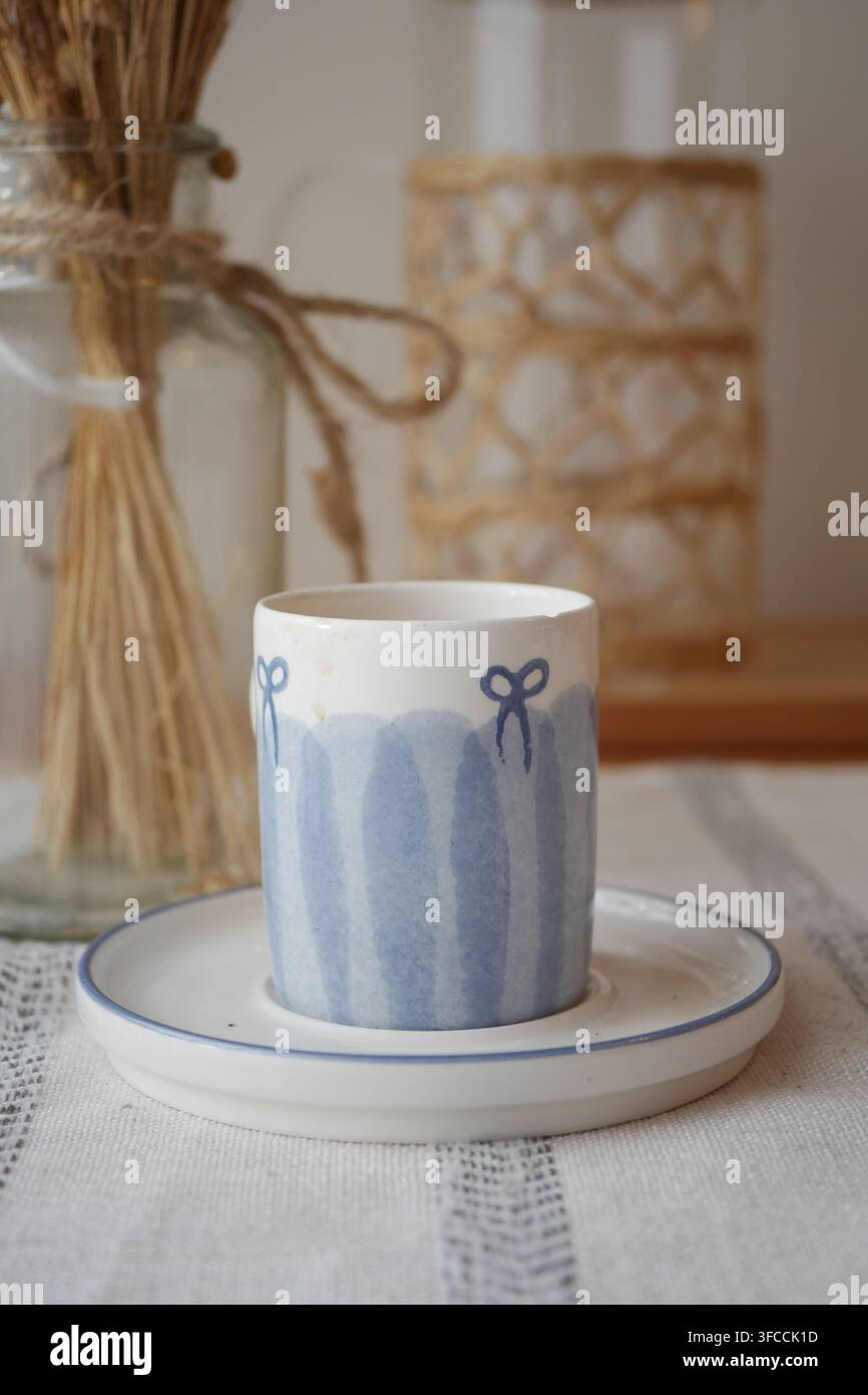 Tazza di caffè su un tavolo con decorazioni e piante Foto Stock