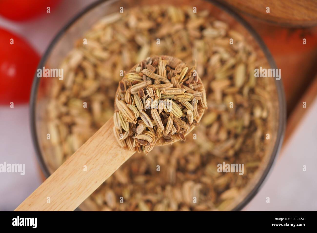 Semi di finocchio in un cucchiaio di legno sul tavolo Foto Stock