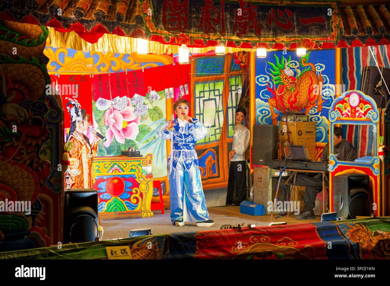Nuova Taipei, Taiwan - 19 feb 2026: La compagnia d'opera taiwanese Yi-shin si esibisce in costumi ornati su un palco all'aperto di un tempio. Foto Stock