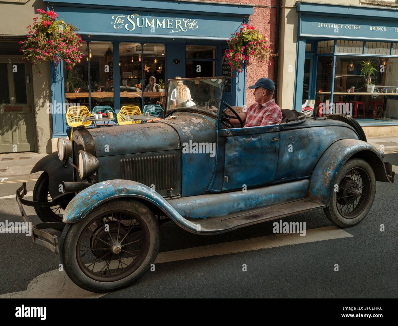 Malmesbury, Wiltshire - Un'auto vintage blu consumata fuori dal The Summer Cafe sulla High Street a Malmesbury. La sua carrozzeria pesantemente patinata, filo di ferro Foto Stock
