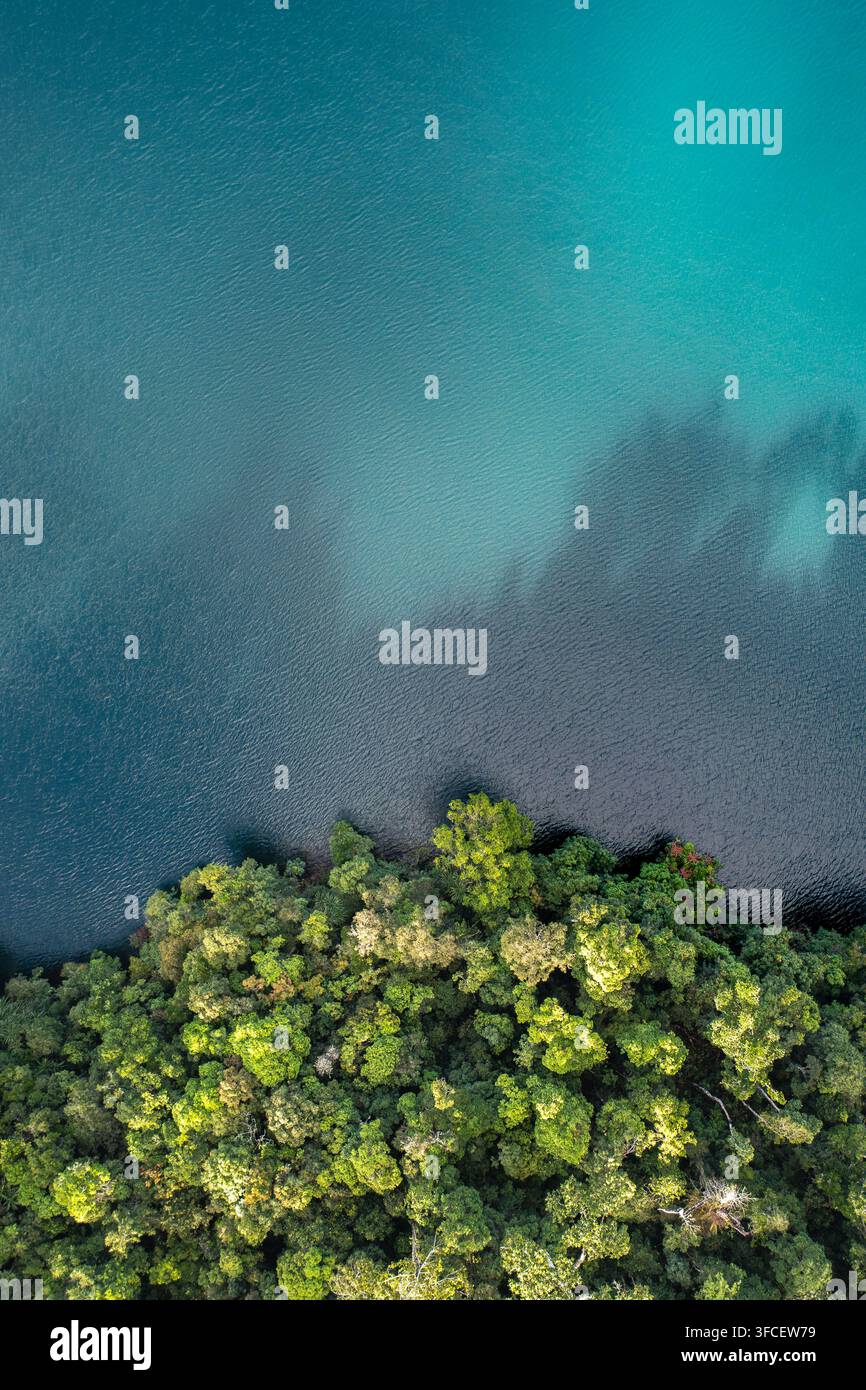 Vista aerea del lago Eacham con la sua acqua profonda di lago vulcanico turchese delimitata da una fitta e lussureggiante chioma di foresta pluviale nelle Atherton Tablelands, Queensland Foto Stock