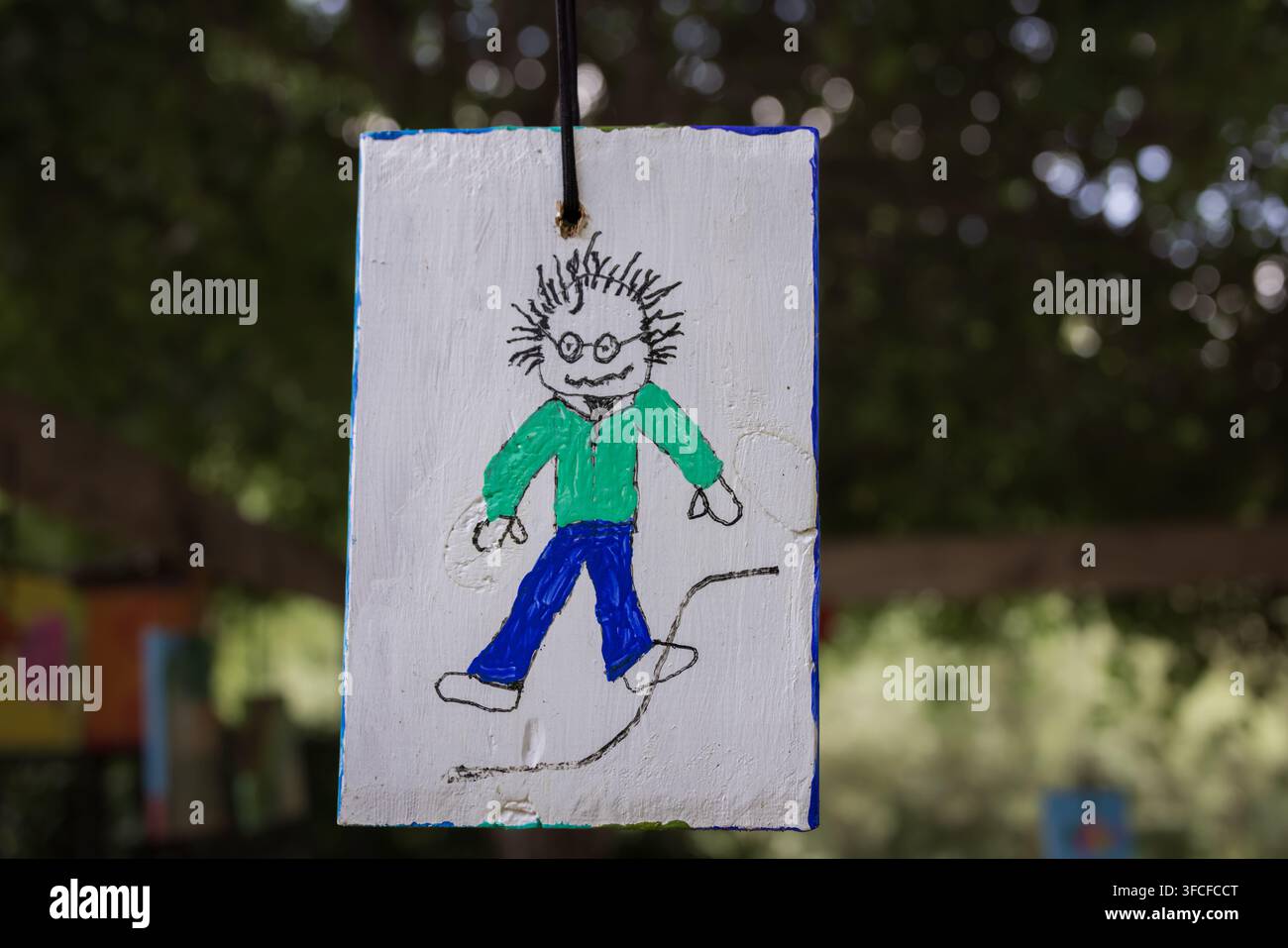 Un disegno bizzarro di un bambino di una figura di bastoncino con capelli a punta, che indossa occhiali, appeso a una corda all'aperto a Cramahe. L'illustrazione giocosa Foto Stock