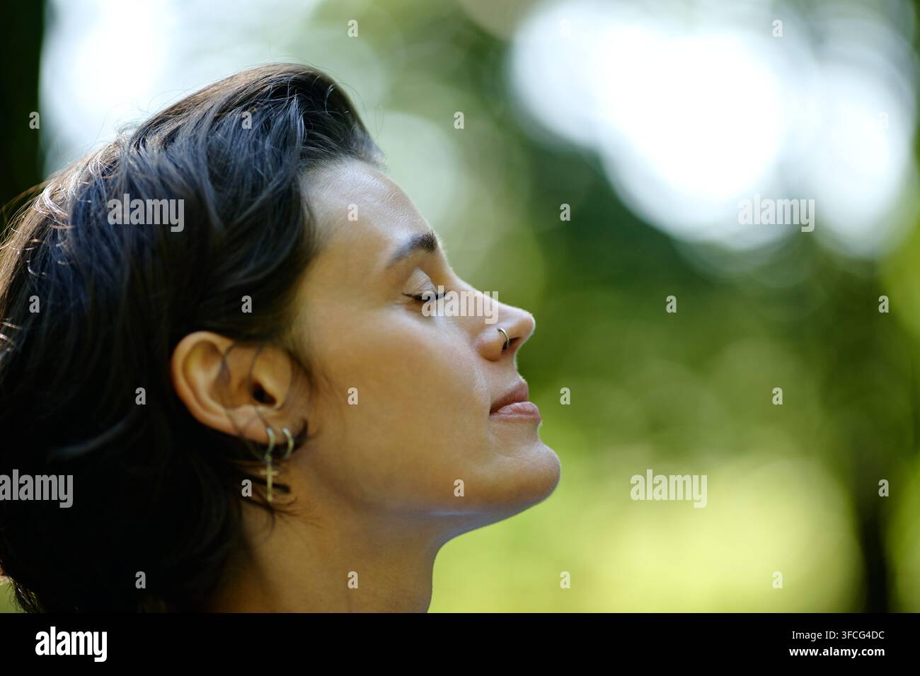 Donna che medita con gli occhi chiusi durante una sessione di psicoterapia all'aperto Foto Stock