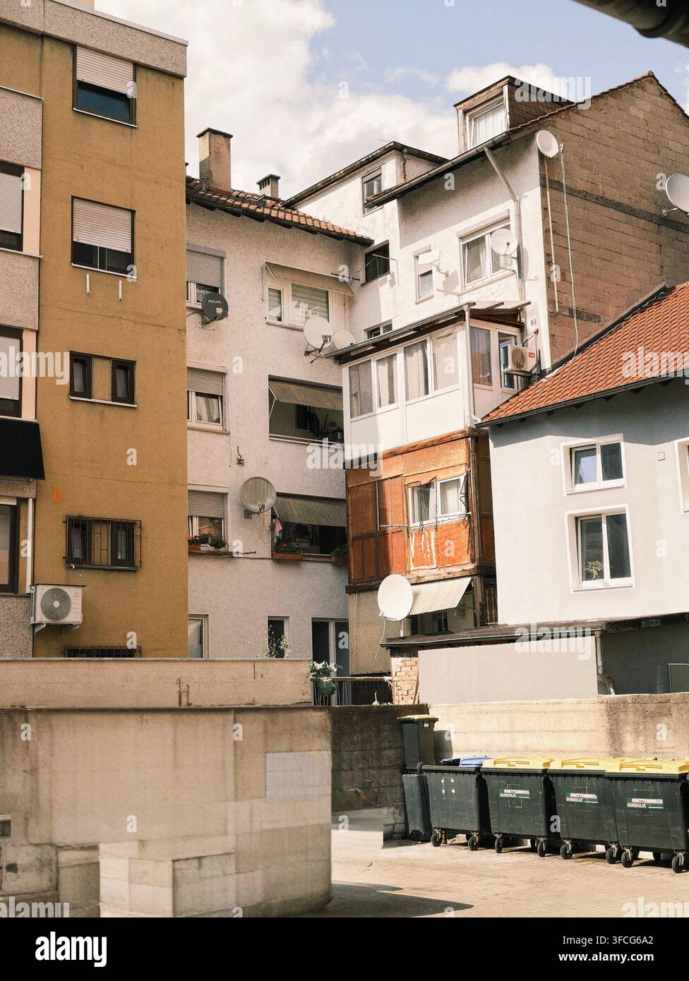 Facciate di palazzine con parabliche e camini sul tetto sotto il piatto Foto Stock
