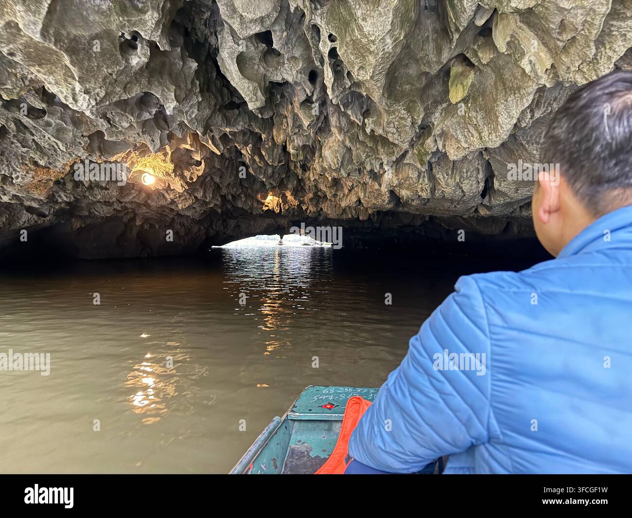 Avvicinamento a un soffitto molto basso della prima grotta bassa - Grotta Ca (Hang Ca) sul fiume Ngo Dong che si snoda tra i campi di riso e le scogliere - Immagine stock catturata con smartphone