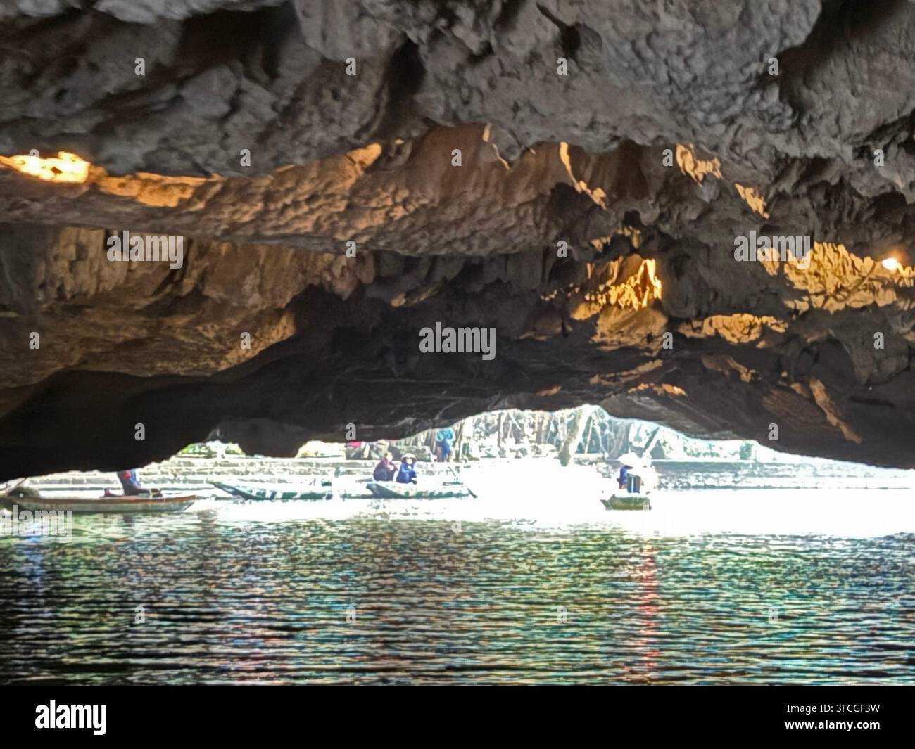 Sotto un soffitto basso di Hang Ba (grotta di Ba) sul fiume Ngo Dong che si snoda tra i campi di riso e le ripide montagne karstiche di calcare (montagne) - Immagine stock catturata con smartphone