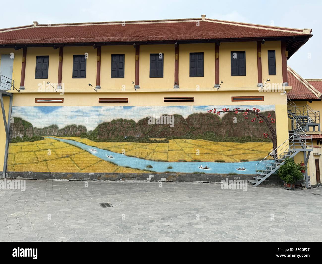 Un grande murale della fiume Ngo Dong che mostra le tre grotte con le ripide montagne karstiche di calcare circostanti e i campi di riso a Ninh Binh - Immagine stock catturata con smartphone