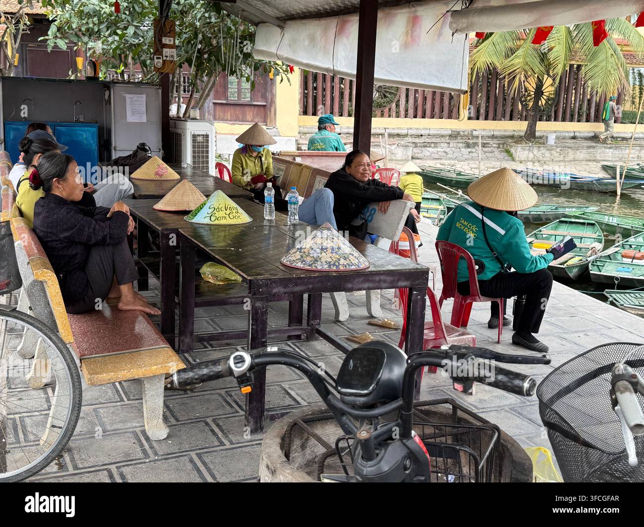 Un lungo bagno con una grande TV per le guide di canottaggio a Tam Coc, provincia di Ninh Binh nella regione del delta del fiume Rosso del nord del Vietnam   La tecnica di remare con i piedi - Immagine stock catturata con smartphone