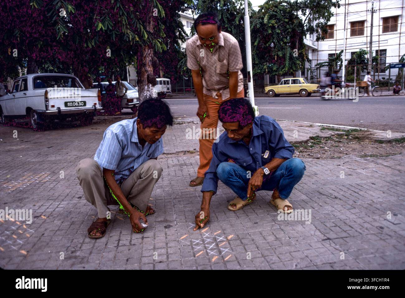 Persone che giocano a un gioco sui ciottoli, Phnom Penh, Cambogia, settembre 1988 Foto Stock