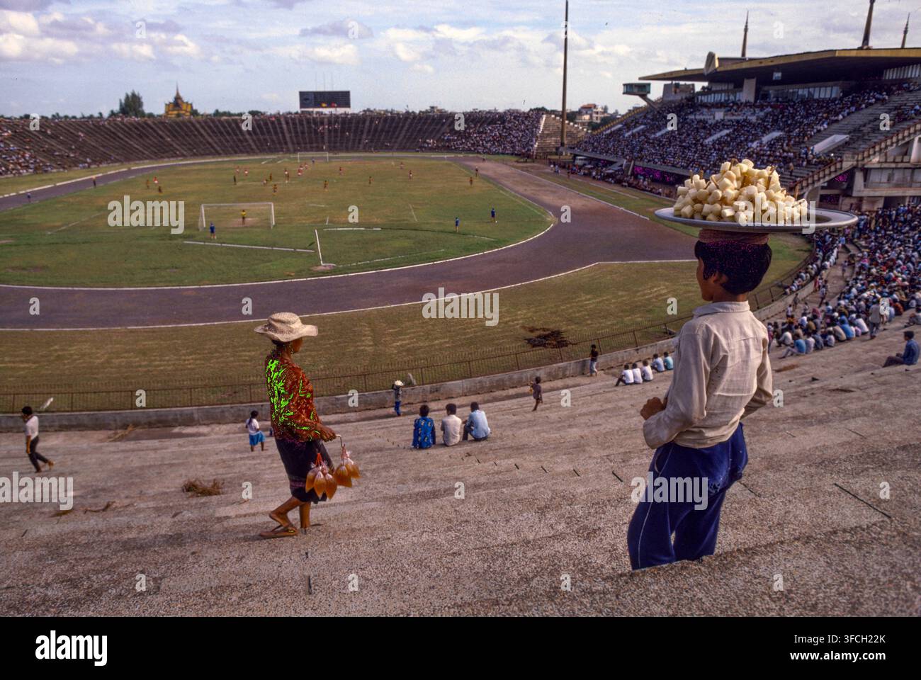 Gente che guarda una partita di football a Phnom Penh, Cambogia, 1987. Foto Stock