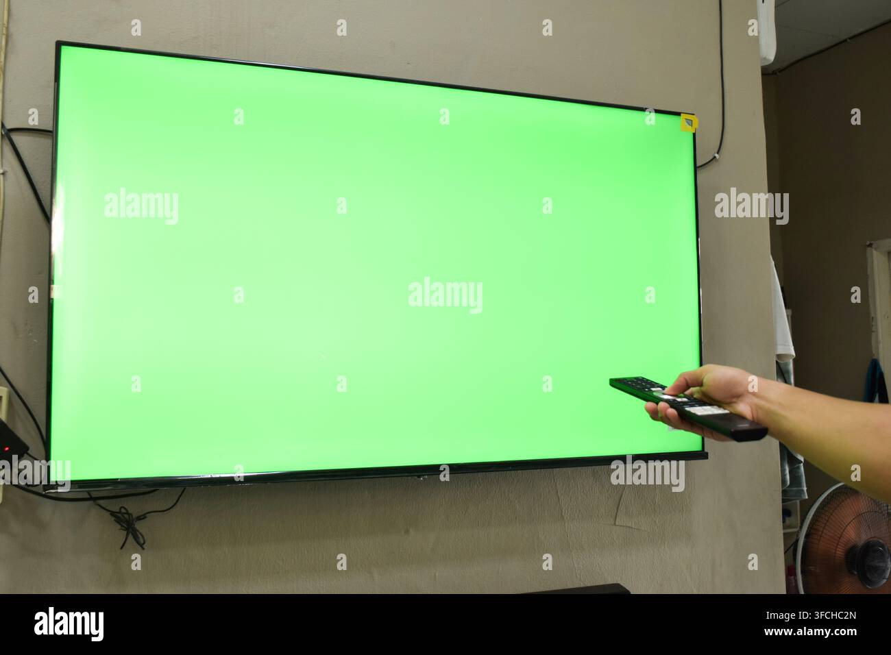 Concetto di schermo verde. Mano giovane uomo sul divano e guardare la tv Foto Stock