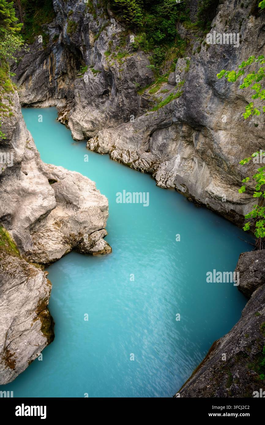 L'acqua turchese scorre attraverso una stretta sezione rocciosa del fiume Lech vicino a Füssen in Bavaria. Delle ripide pareti rocciose grigie e la vegetazione verde racchiudono il Foto Stock