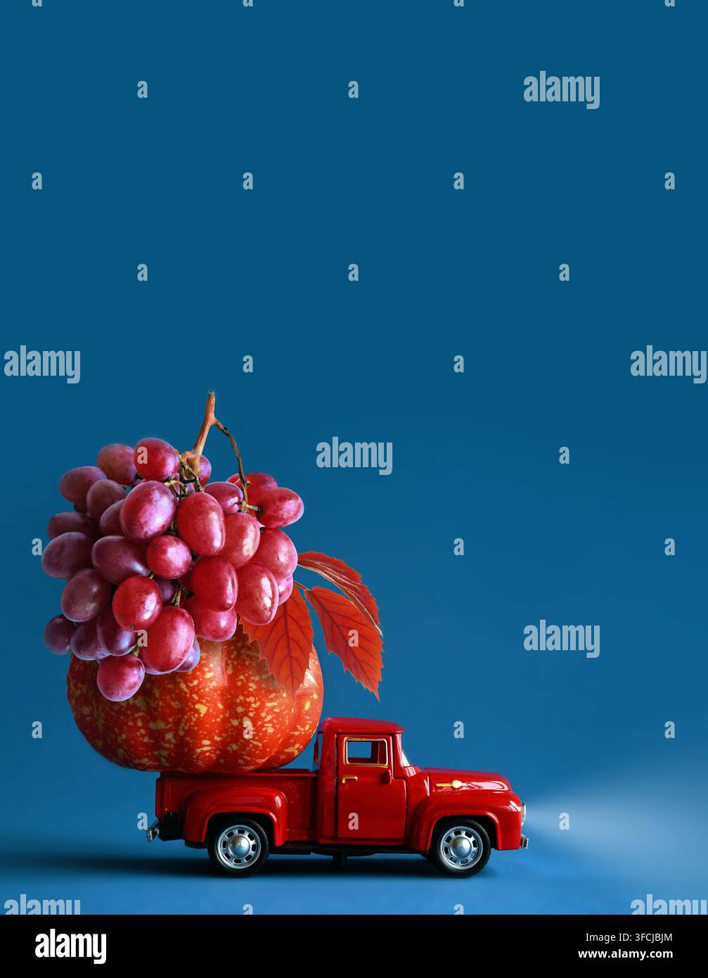 Natura morta autunnale con uva e zucca su un camion. Doni della natura. Foto Stock