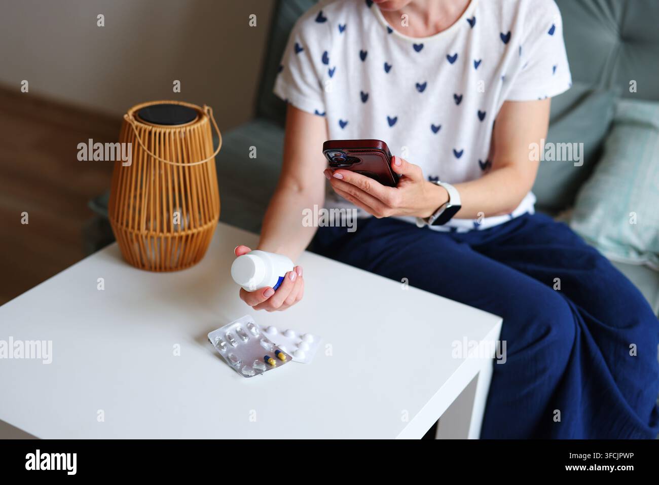 Donna utilizza un chatbot AI per scegliere farmaci a casa, concetto di autodiagnosi e ricerca di consigli medici digitali invece di un medico. Foto Stock
