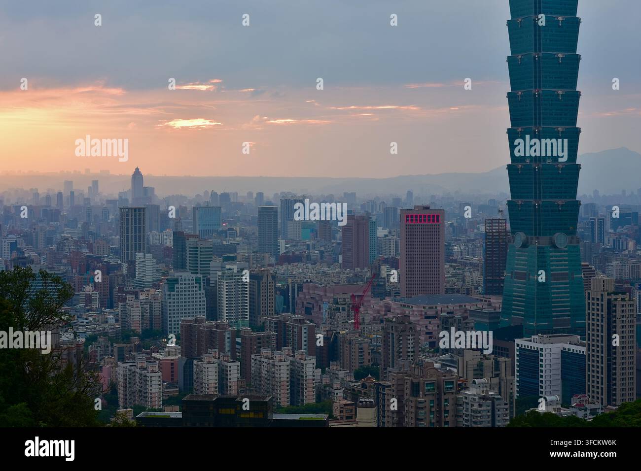 Il grattacielo iconico di Taipei 101 che si erge sulla linea dell'orizzonte al tramonto di Taipei, Taiwan. Foto Stock