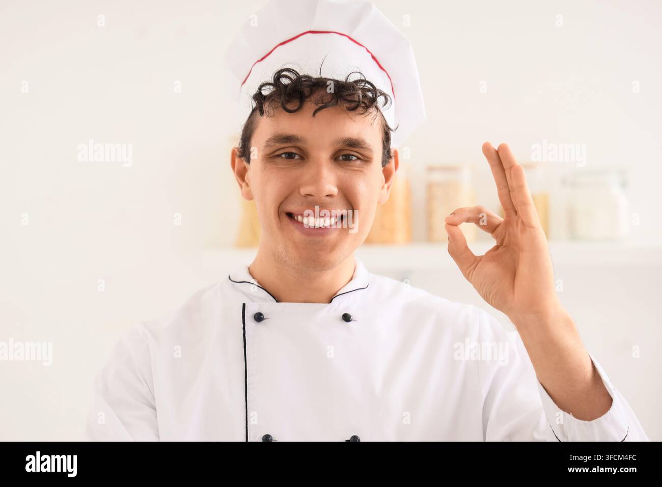 Eccellenza culinaria e qualità degli alimenti, chef professionista che mostra un gesto di approvazione in cucina per gli standard di servizio del ristorante e dell’industria dell’ospitalità Foto Stock