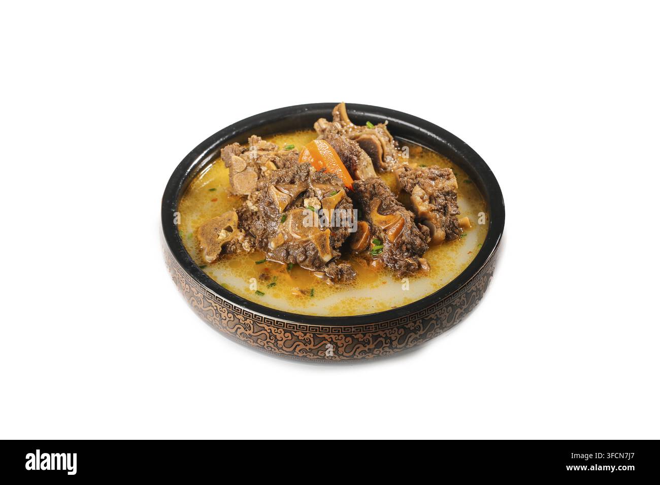 Zuppa di carne servita in una ciotola nera isolata su sfondo bianco. Foto Stock