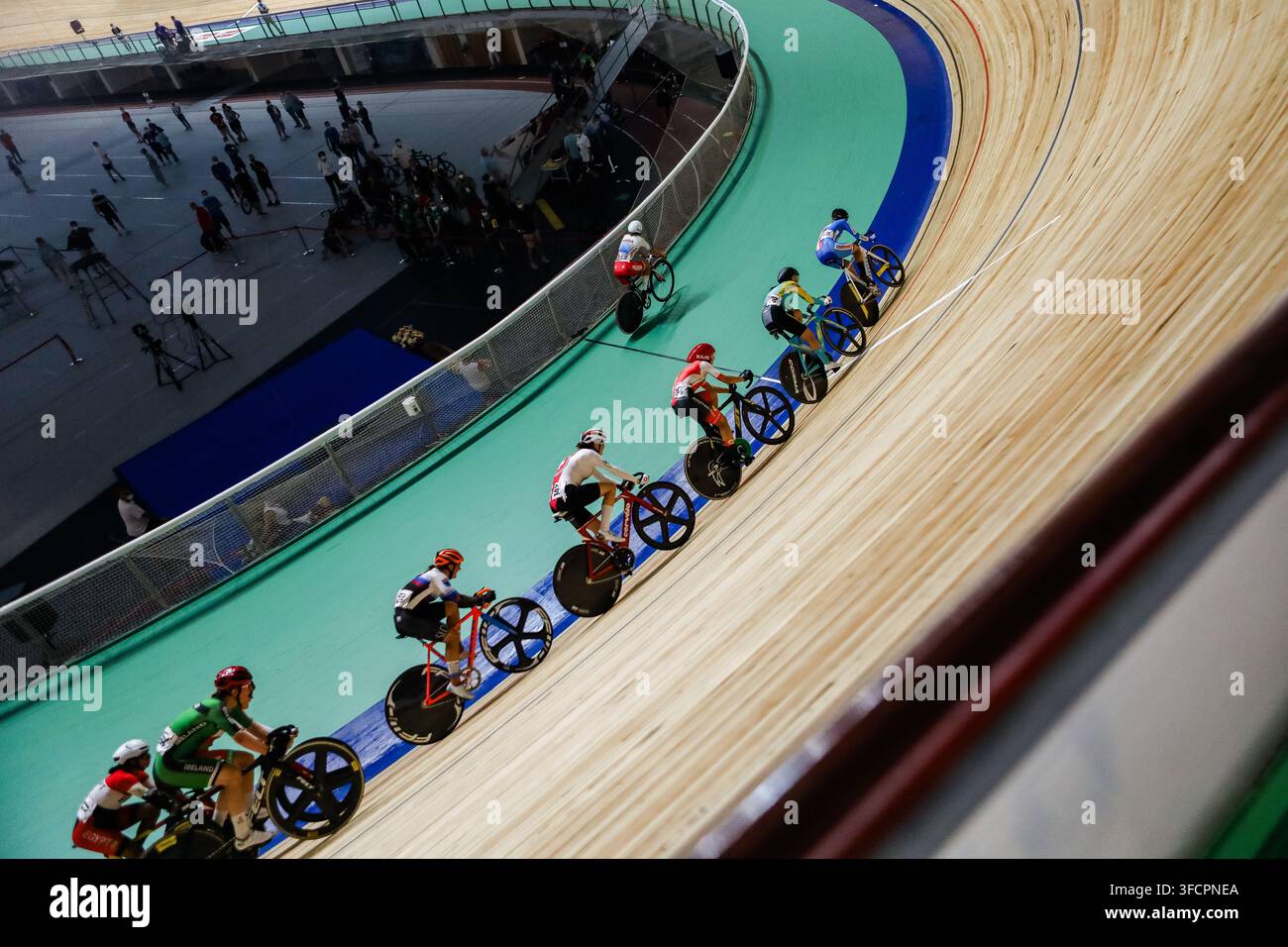 Ciclisti su pista che corrono su una velodromo in legno ripida Foto Stock