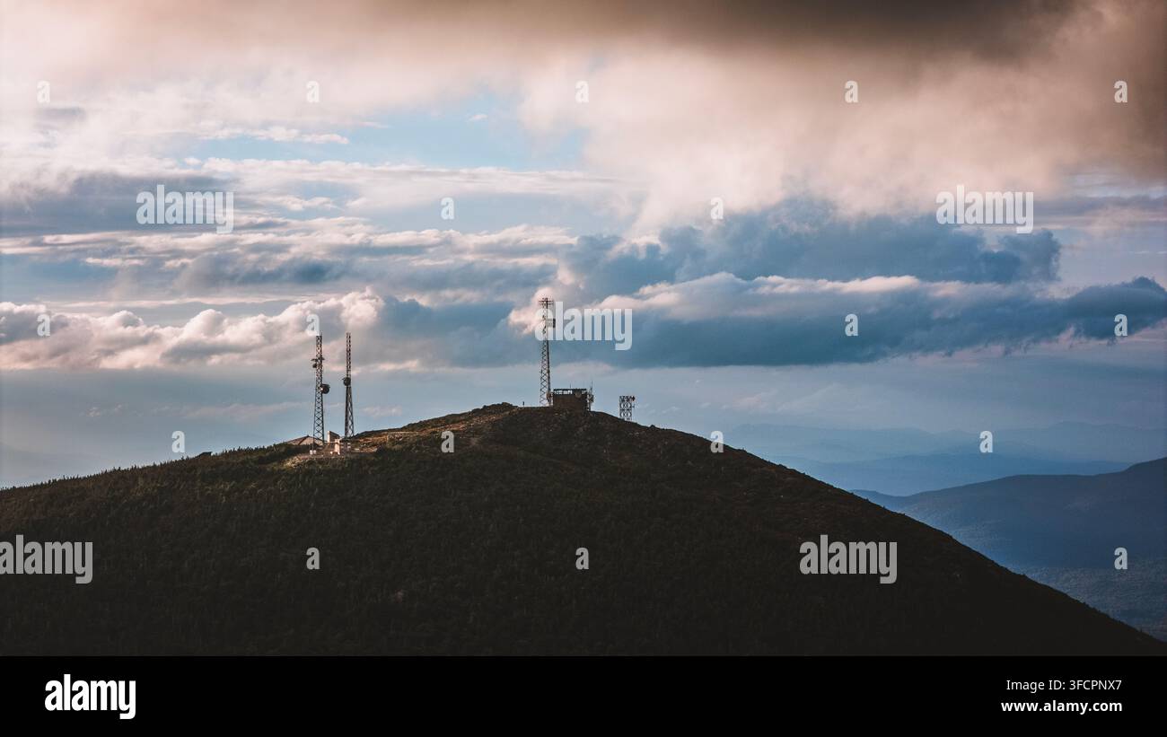 Torri di comunicazione distanti sulla cima di una montagna boscosa Foto Stock
