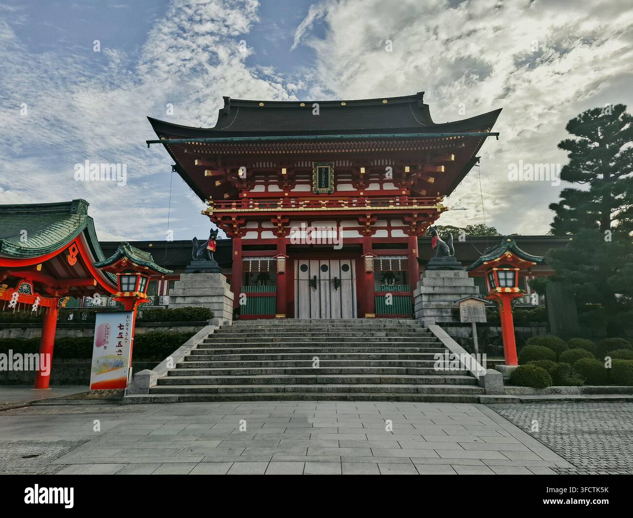 Vista dell'iconico cancello rosso Romon al santuario di Fushimi Inari-taisha con scale in pietra e architettura tradizionale giapponese a Kyoto, Kyoto, Giappone. Foto Stock