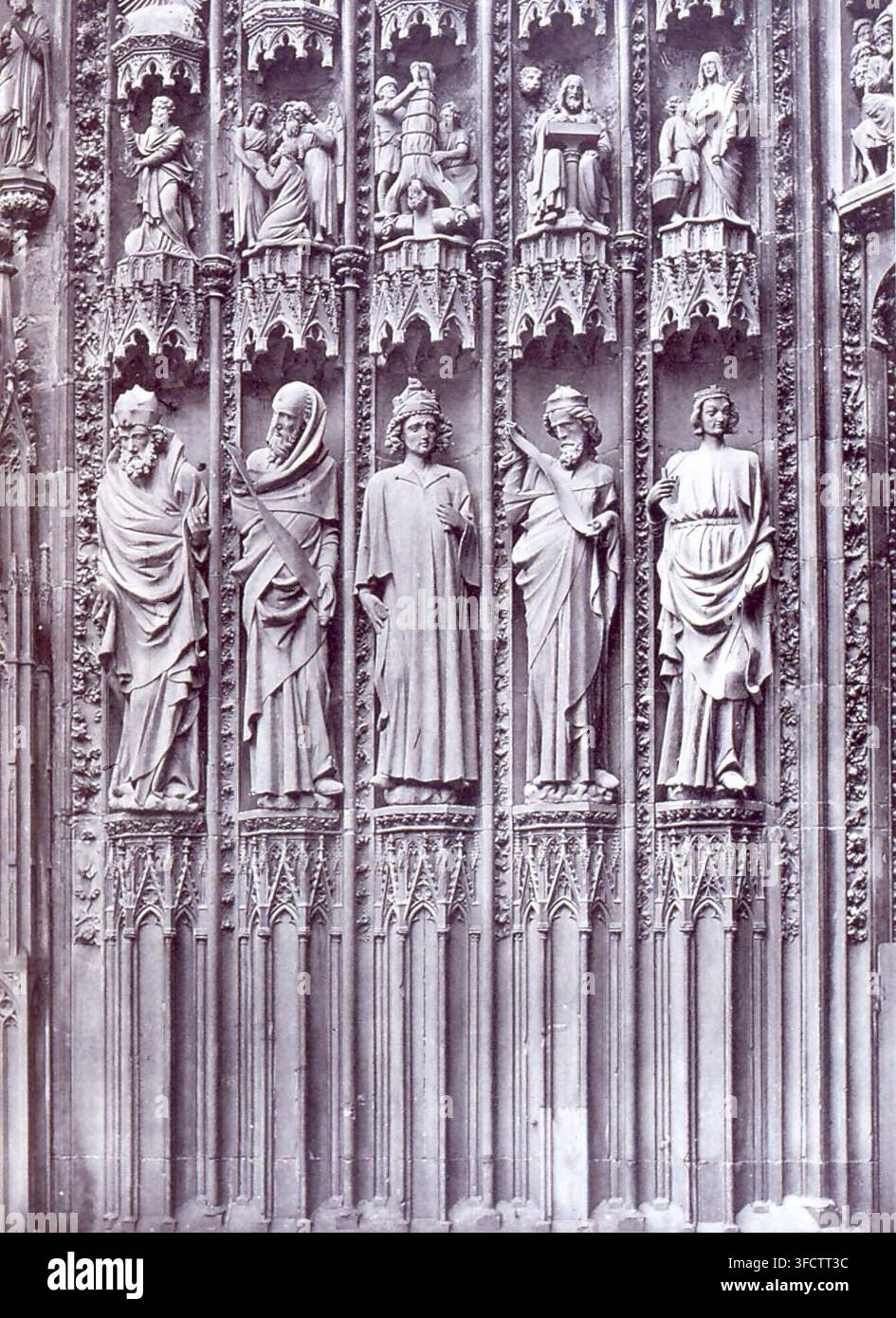 Un'intaglio in pietra dettagliata sul portale centrale della cattedrale di Strasburgo, che presenta più figure in abiti in stile gotico, con dettagli architettonici intricati che le circondano, in una fotografia del landmark di Strasburgo. Foto Stock