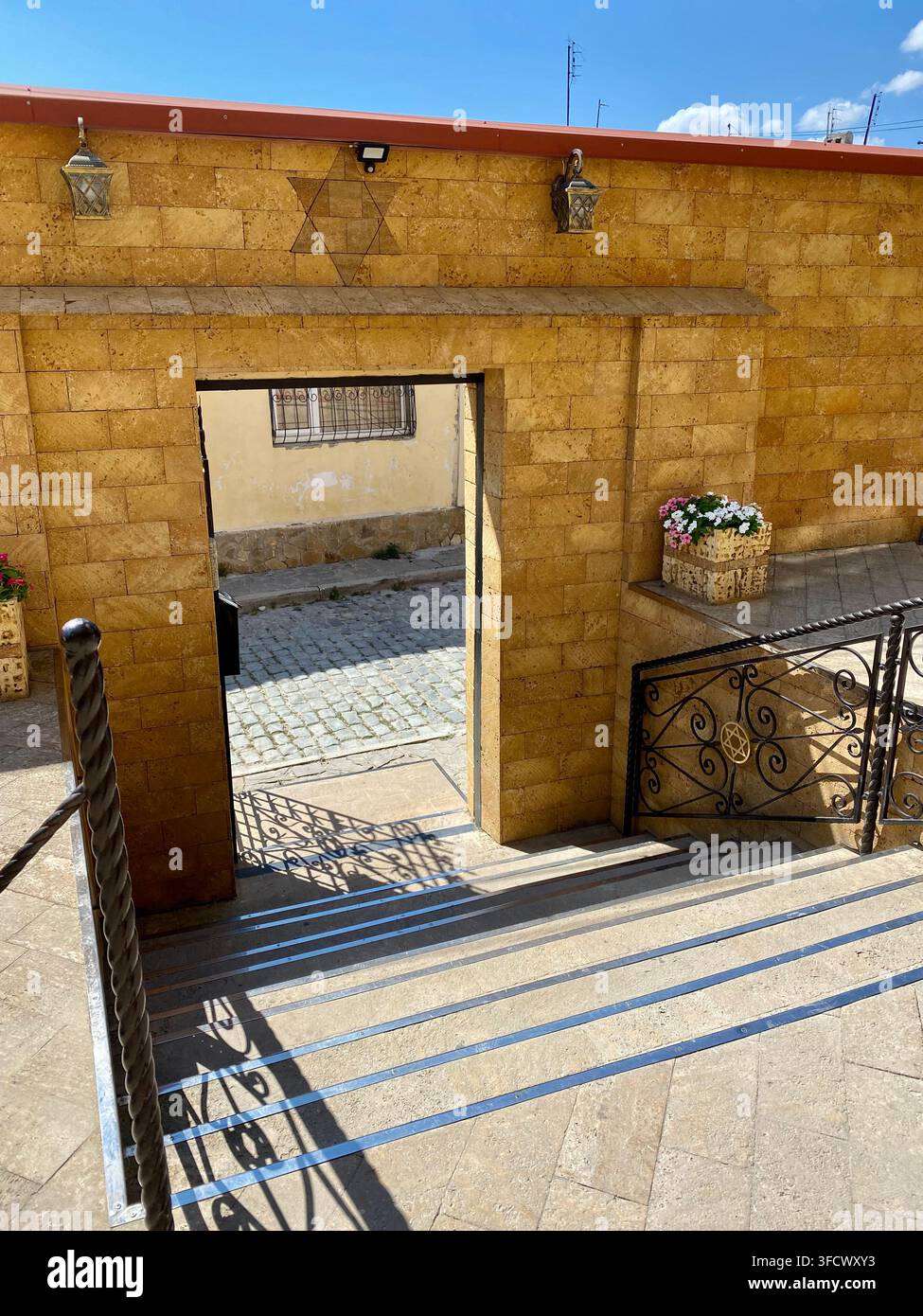 Scalinata in pietra e simboli ebraici decorativi appaiono in un cortile storico - Immagine stock catturata con smartphone