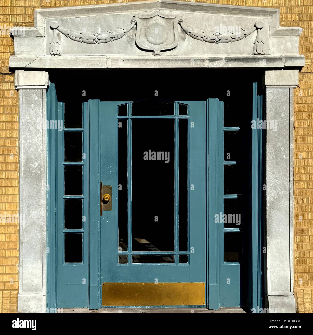 Porta blu circondata da ornato intonaco classico con ghirlande scolpite e dettagli architettonici decorativi. Foto Stock