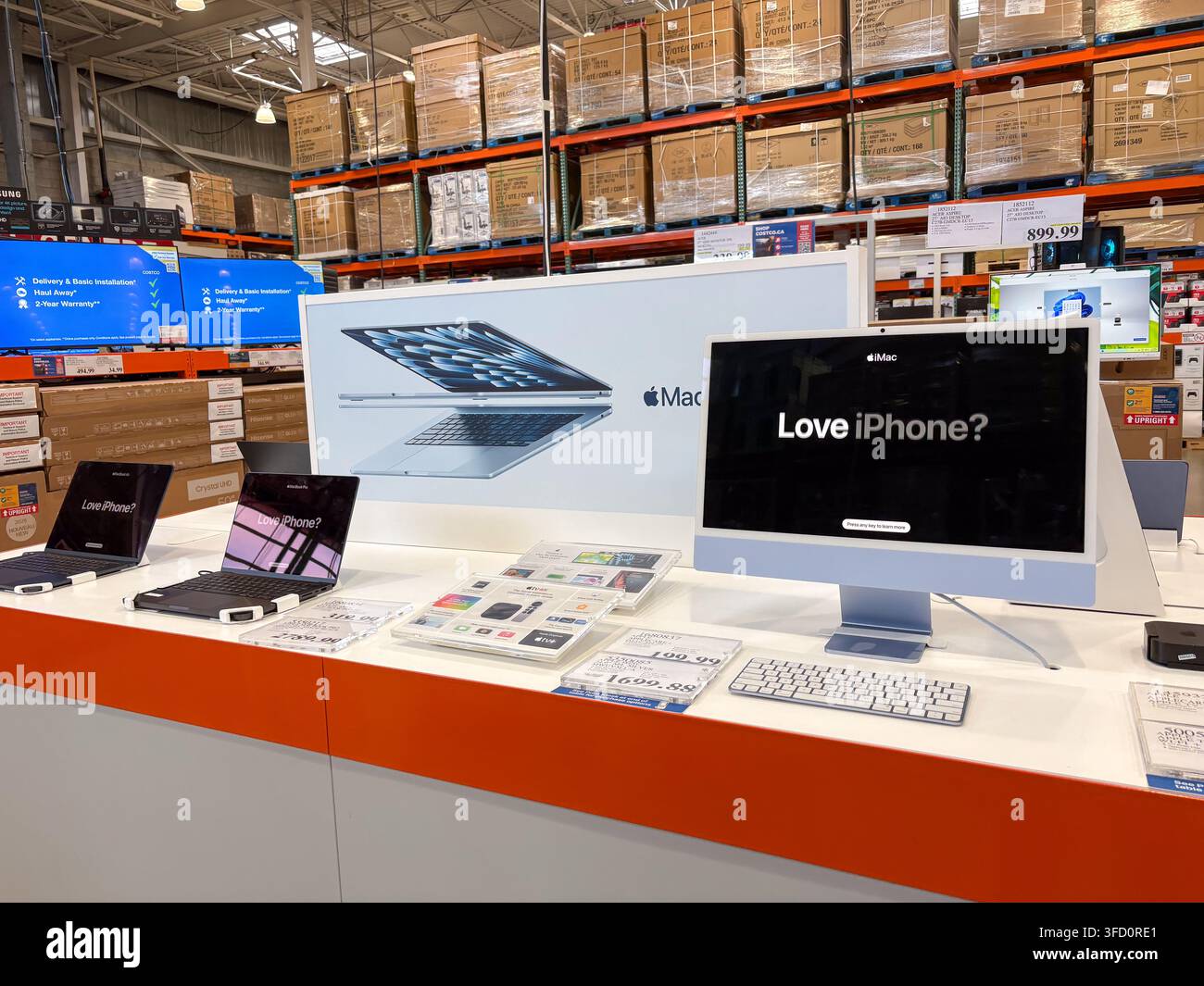La sezione dei prodotti Apple all'interno del negozio di magazzino Costco che mostra computer, laptop e esposizioni promozionali. Foto Stock