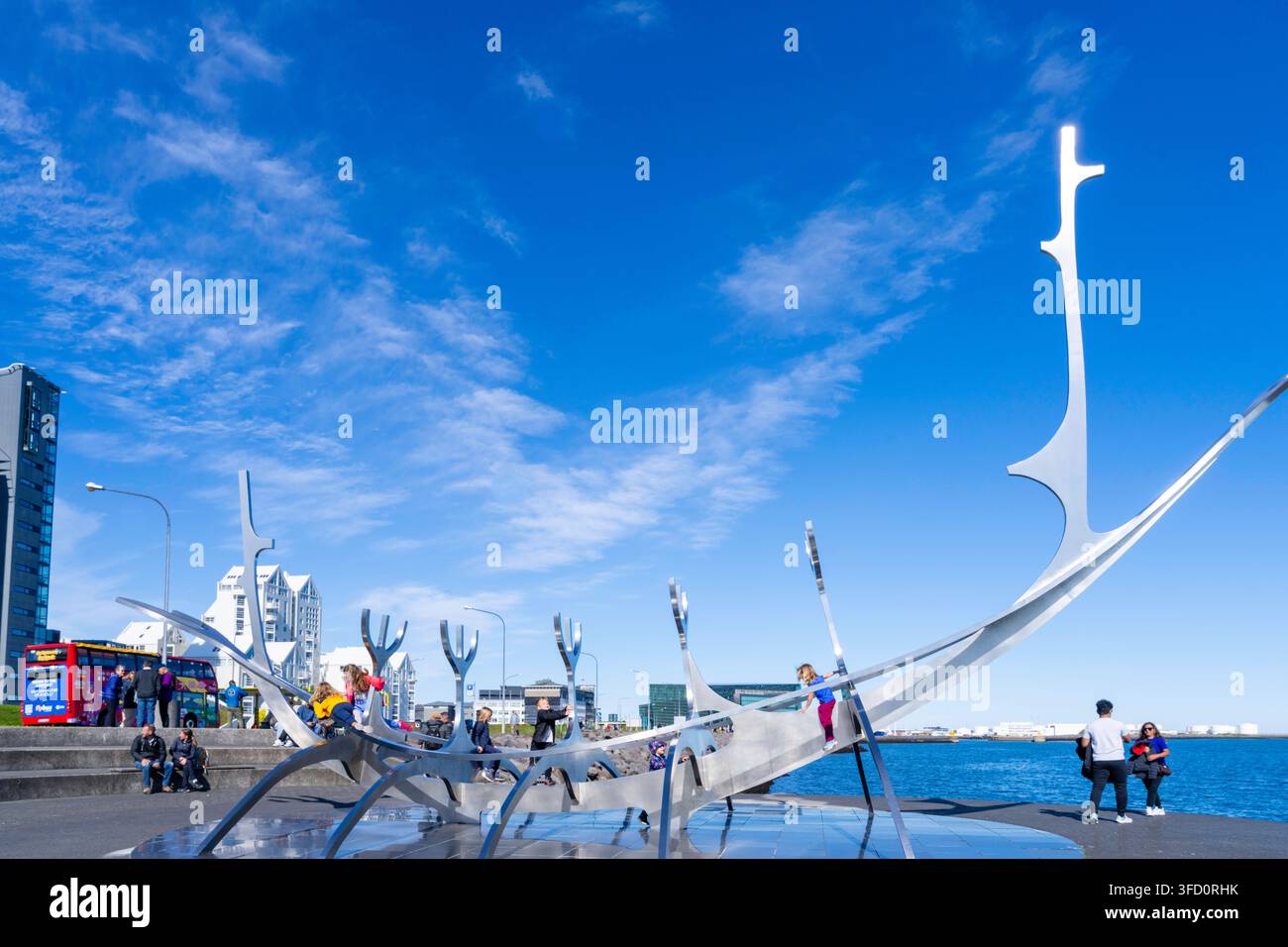 Bambini si arrampicano sulla scultura Sun Voyager creata da J—n Gunnar çrnason nel porto di Reykjavik, Islanda. Foto Stock