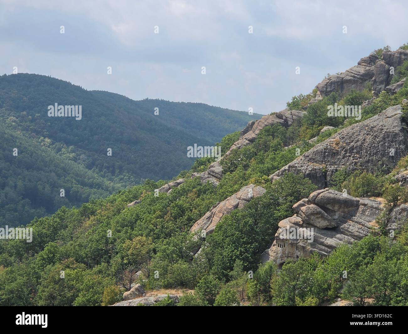 Formazione rocciosa che assomiglia a un volto umano che guarda il cielo vicino a Nochevo, nei Rodopi orientali, Bulgaria - Immagine stock catturata con smartphone