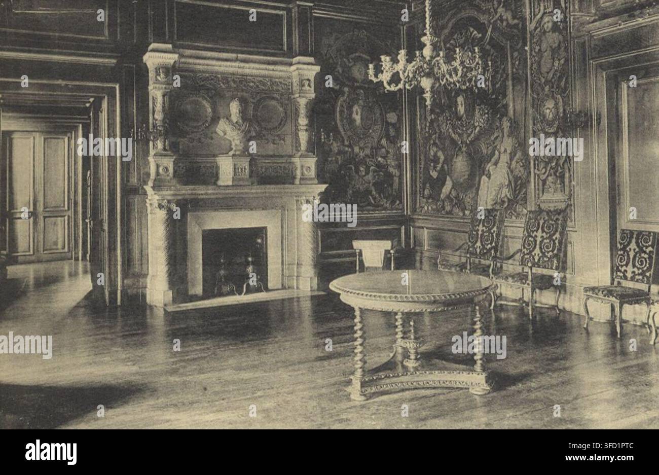 Una fotografia del XX secolo di una stanza dello Château de Pau, Pirenei Atlantici, con un grande arazzo, un camino, un tavolo rotondo e diverse sedie. Foto Stock