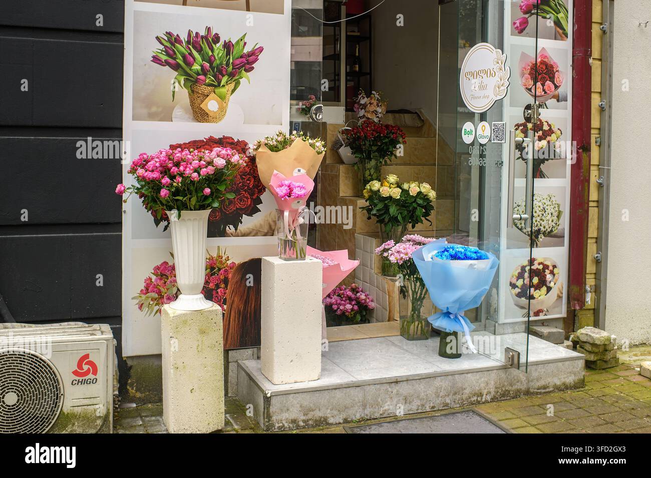 Batumi, Georgia - 28 agosto 2026: Mazzi di fiori freschi e colorati sono disposti in vasi all’ingresso di una fioreria all’aperto su una strada cittadina. Foto Stock
