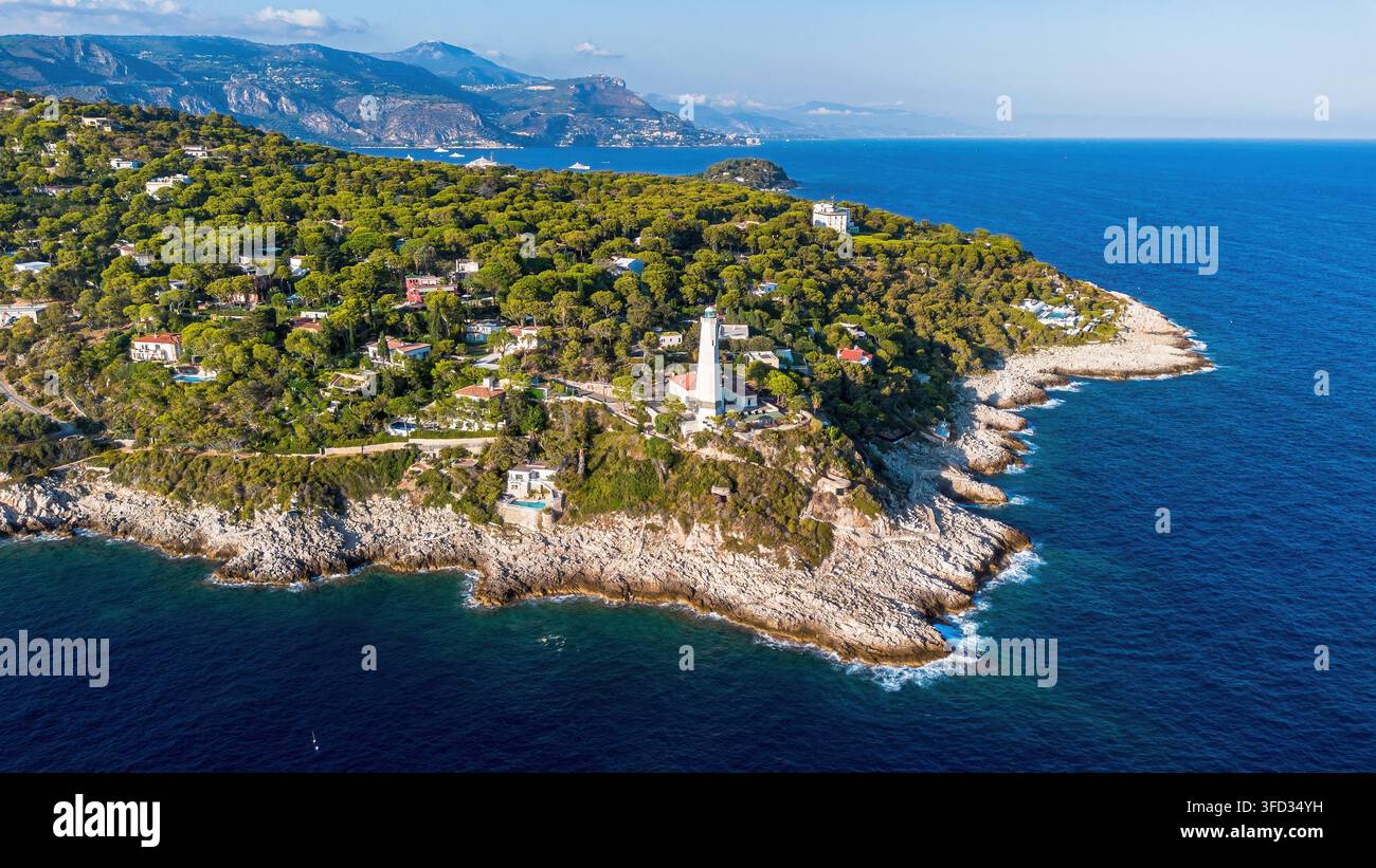 Vista aerea con drone del faro storico di Phare du Cap Ferrat, della costa rocciosa e del Mar Mediterraneo a Saint-Jean-Cap-Ferrat, Francia Foto Stock