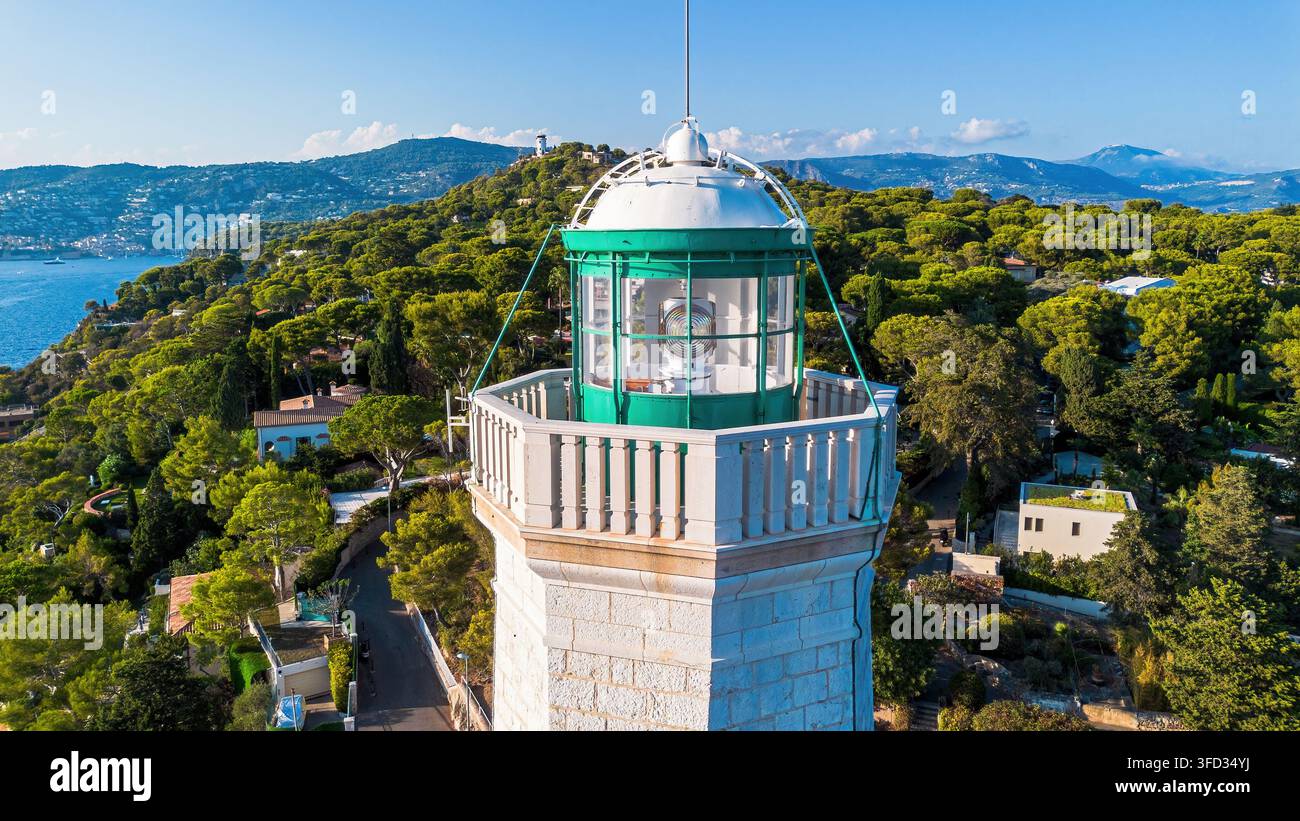 Vista aerea con drone del faro di Capo Ferrato circondato da boschi di pini e dal Mar Mediterraneo a Saint-Jean-Cap-Ferrat, Francia Foto Stock