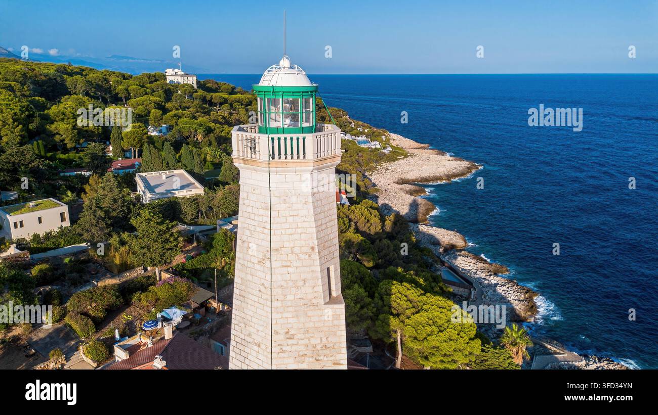 Vista aerea con drone del faro storico di Phare du Cap Ferrat, della costa rocciosa e del Mar Mediterraneo a Saint-Jean-Cap-Ferrat, Francia Foto Stock