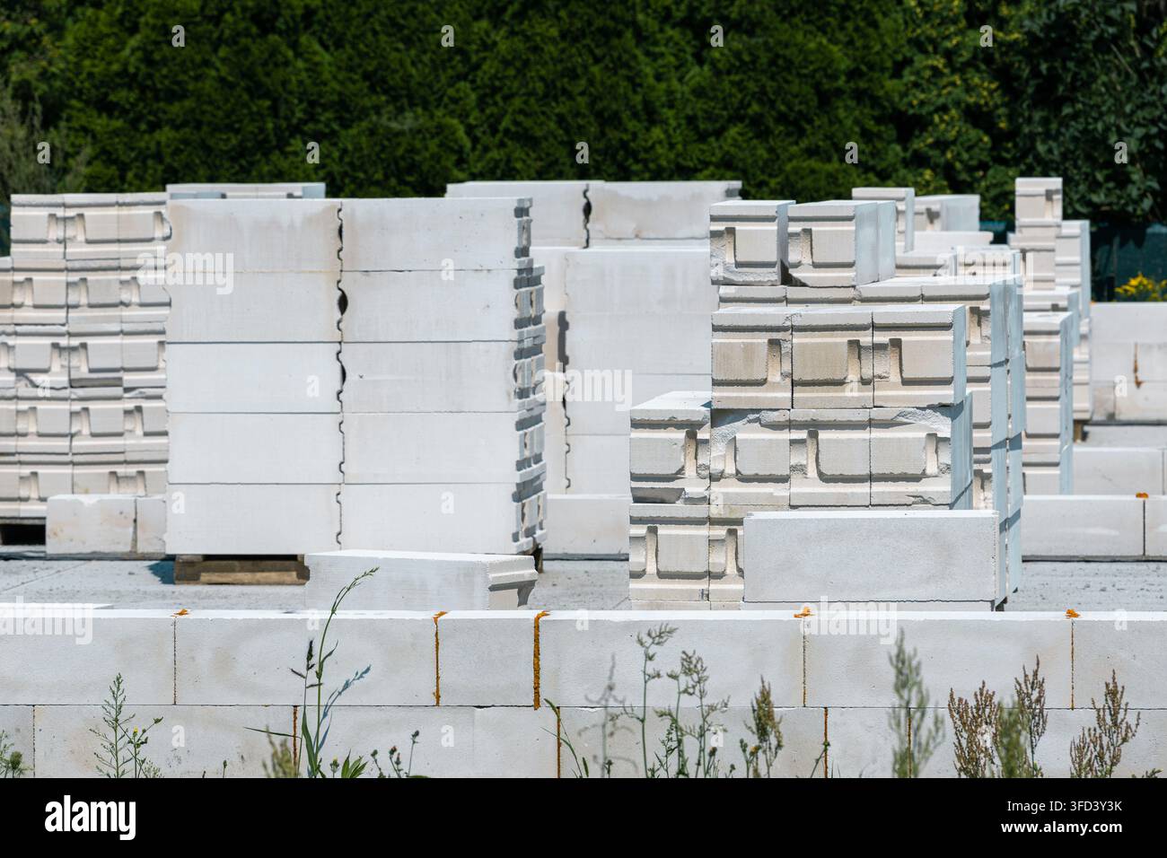 I blocchi di cemento poroso sono disposti nel cantiere edile. Il materiale viene utilizzato per le pareti delle case monofamiliari moderne. Foto Stock