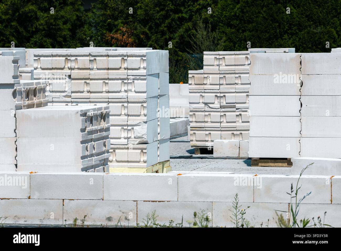 I blocchi di cemento poroso sono disposti nel cantiere edile. Il materiale viene utilizzato per le pareti delle case monofamiliari moderne. Foto Stock