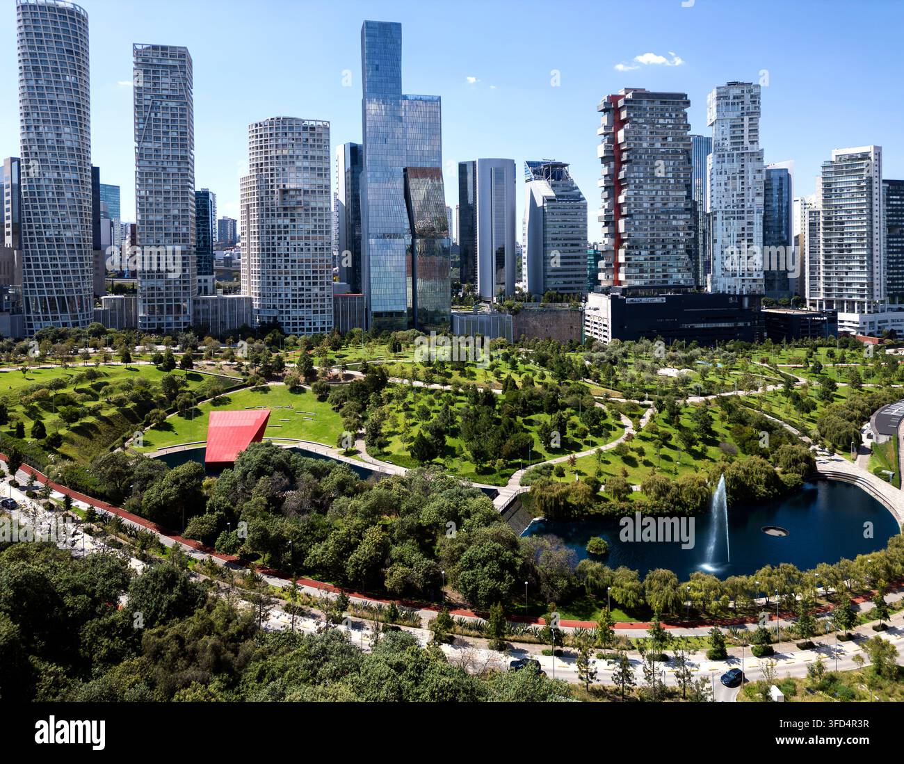 Parque La Mexicana, Santa Fe, Città del Messico, Messico, che mostra il lago del parco e la fontana con moderni grattacieli lungo il Paseo de los Arquitectos Foto Stock