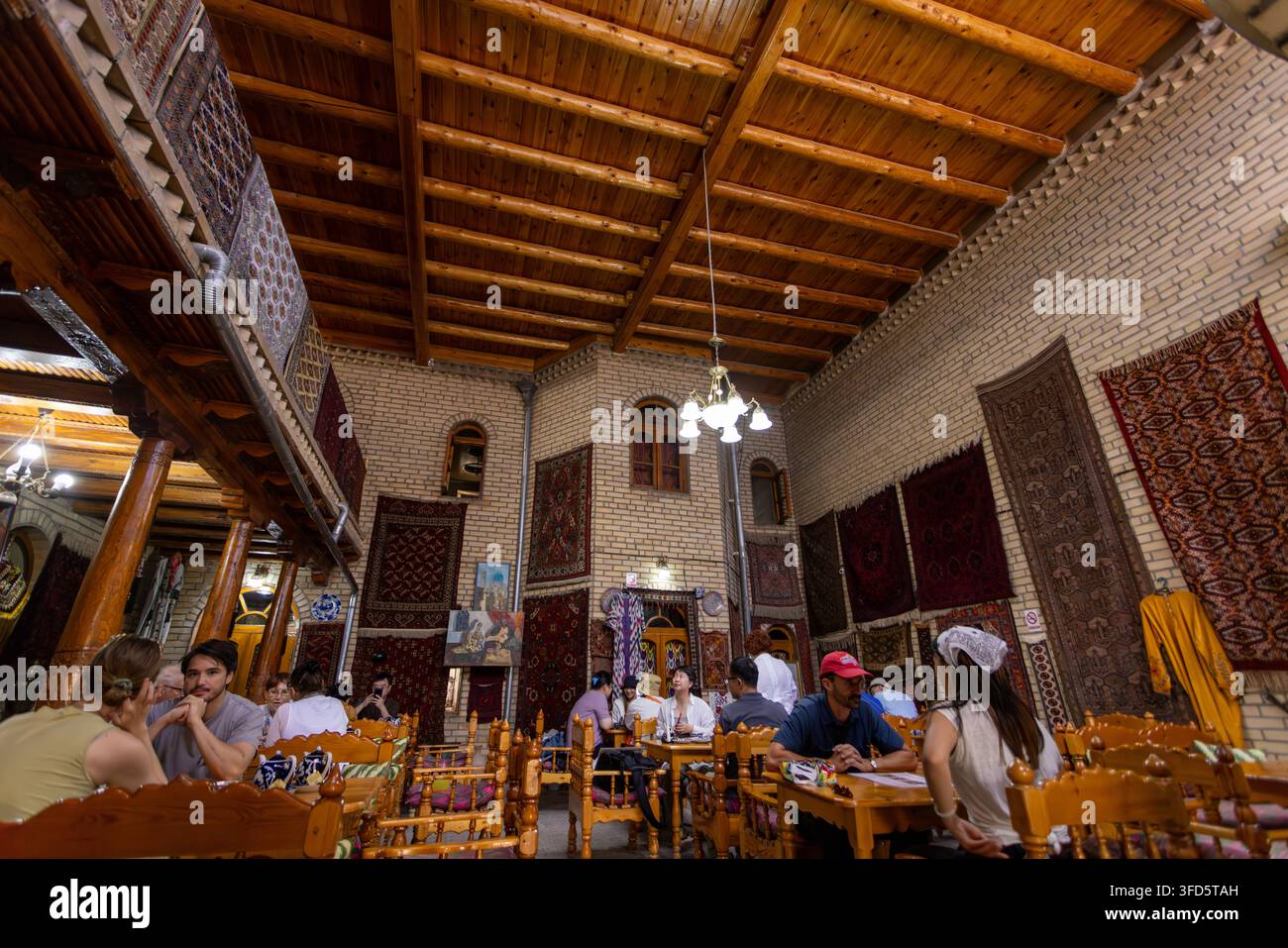 Bukhara, Uzbekistan – 3 ottobre 2024: L'interno del Silk Road Tea House presenta travi in legno, archi in mattoni e un'atmosfera uzbeka autentica. Foto Stock