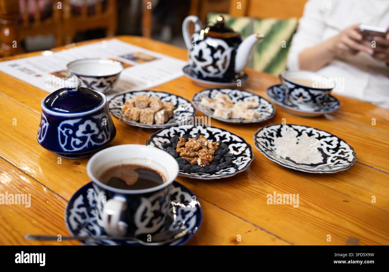 Bukhara, Uzbekistan – 3 ottobre 2024: L'interno del Silk Road Tea House presenta travi in legno, archi in mattoni e un'atmosfera uzbeka autentica. Foto Stock